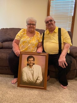 Karen’s mom and dad, Palma and John, with a photo of her late brother, Doug.