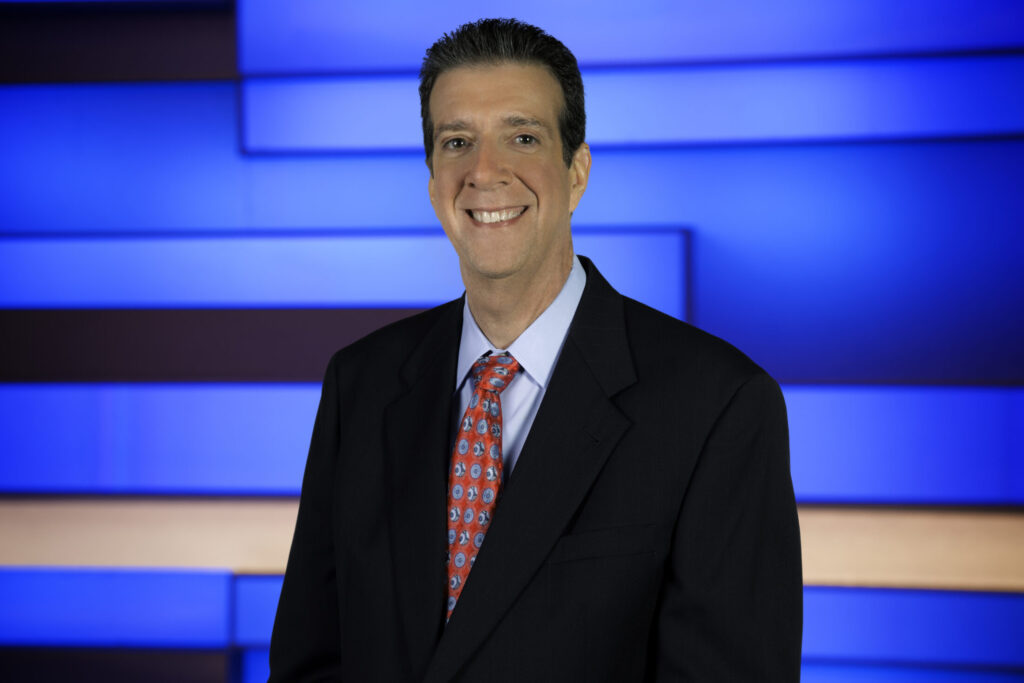 Bert Medina headshot wearing a suite and tie at ABC TV studio