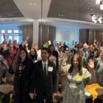 Group of attendees at London symposium 2024. Waving to camera.