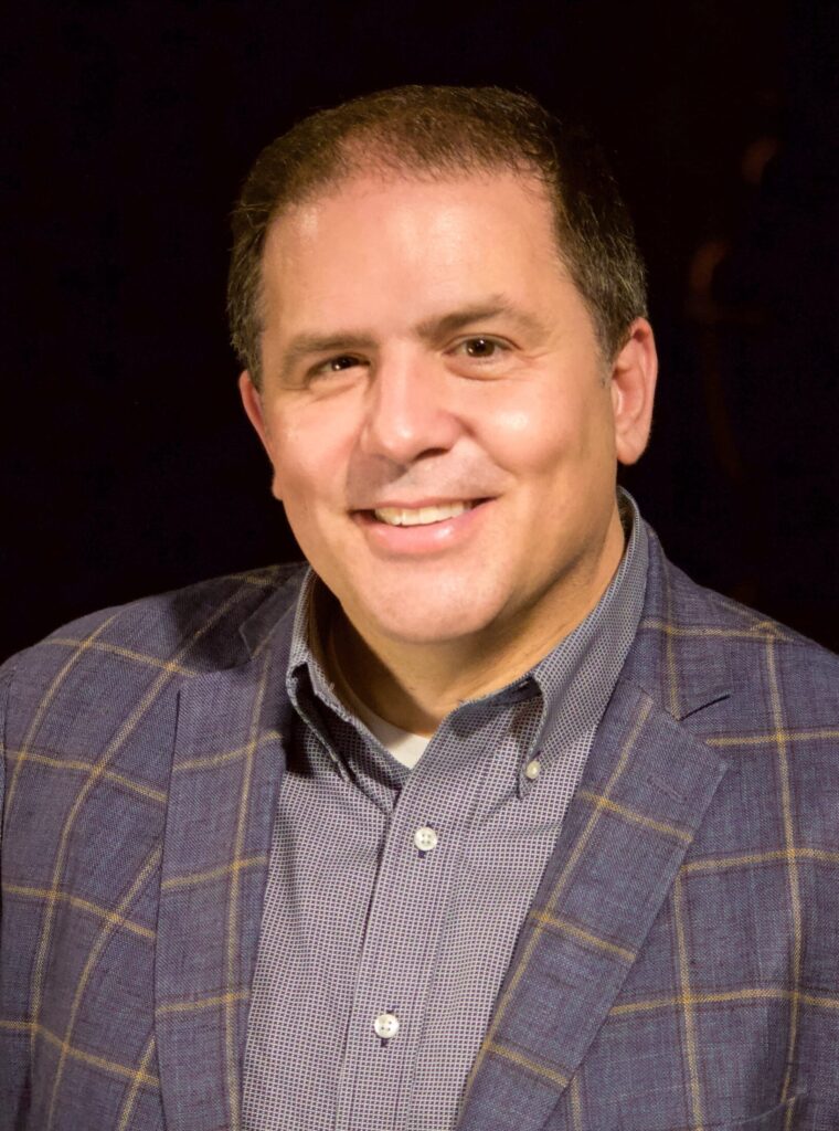 Headshot of director John Simpkins dressed in professional attire