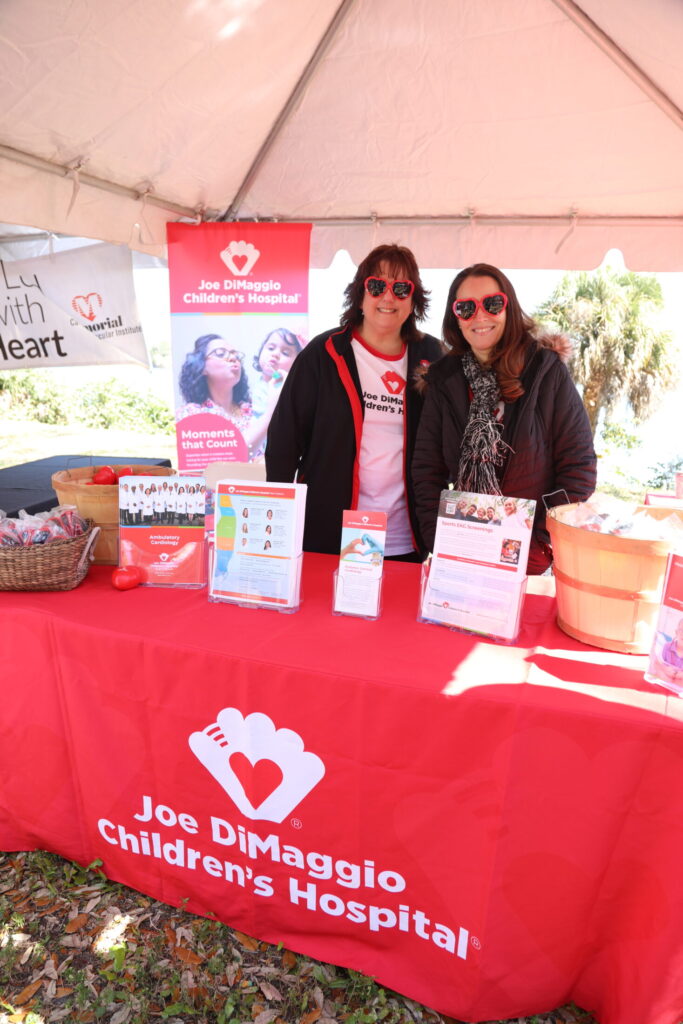 Representatives from Joe DiMaggio children's hospital with logo banner.