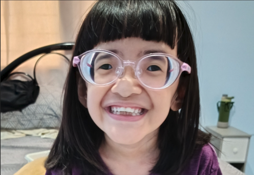 Destinee Jaye lives with early onset Marfan syndrome. She is pictured with black hair, glasses, and a purple shirt.