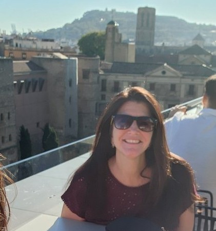 Jeanette lives with Marfan syndrome. She is pictured in front of a vacation scene. She is a volunteer for the Marfan Foundation. 