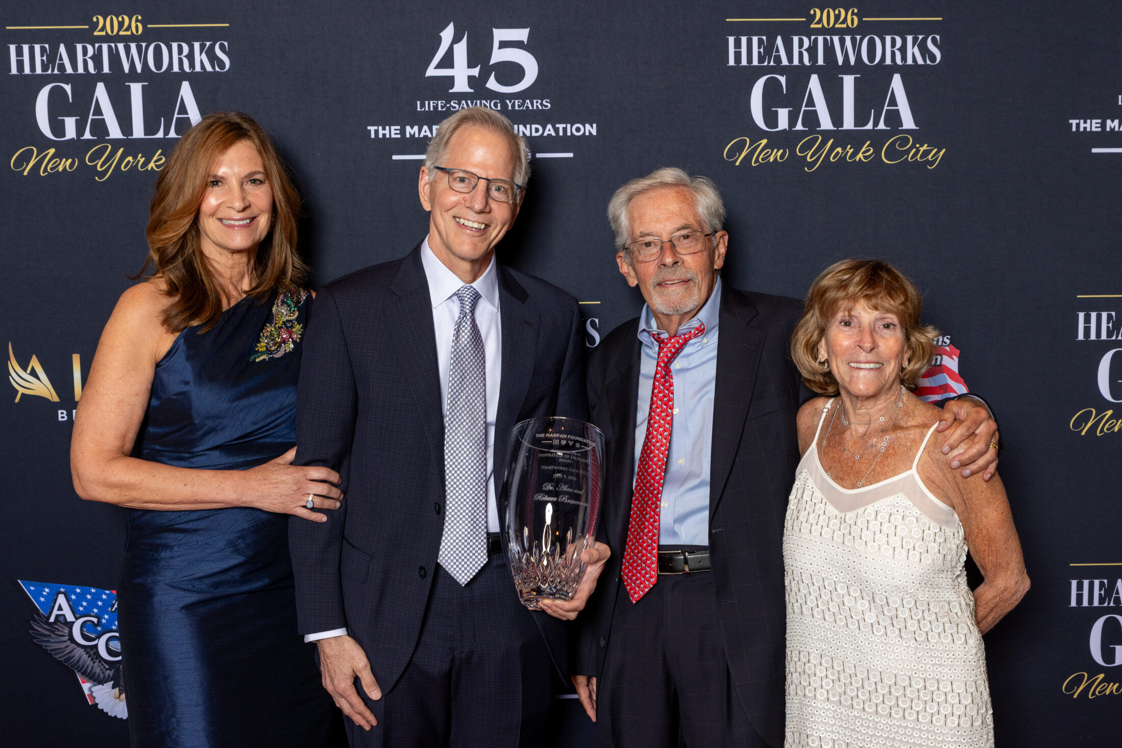 Rebecca Braverman, Dr. Alan Braverman, Dr. Reed Pyeritz, and Jane Tumpson pose in front of the Foundation's logo backdrop with the Inspiration of Excellence Award at NYC Heartworks 2026