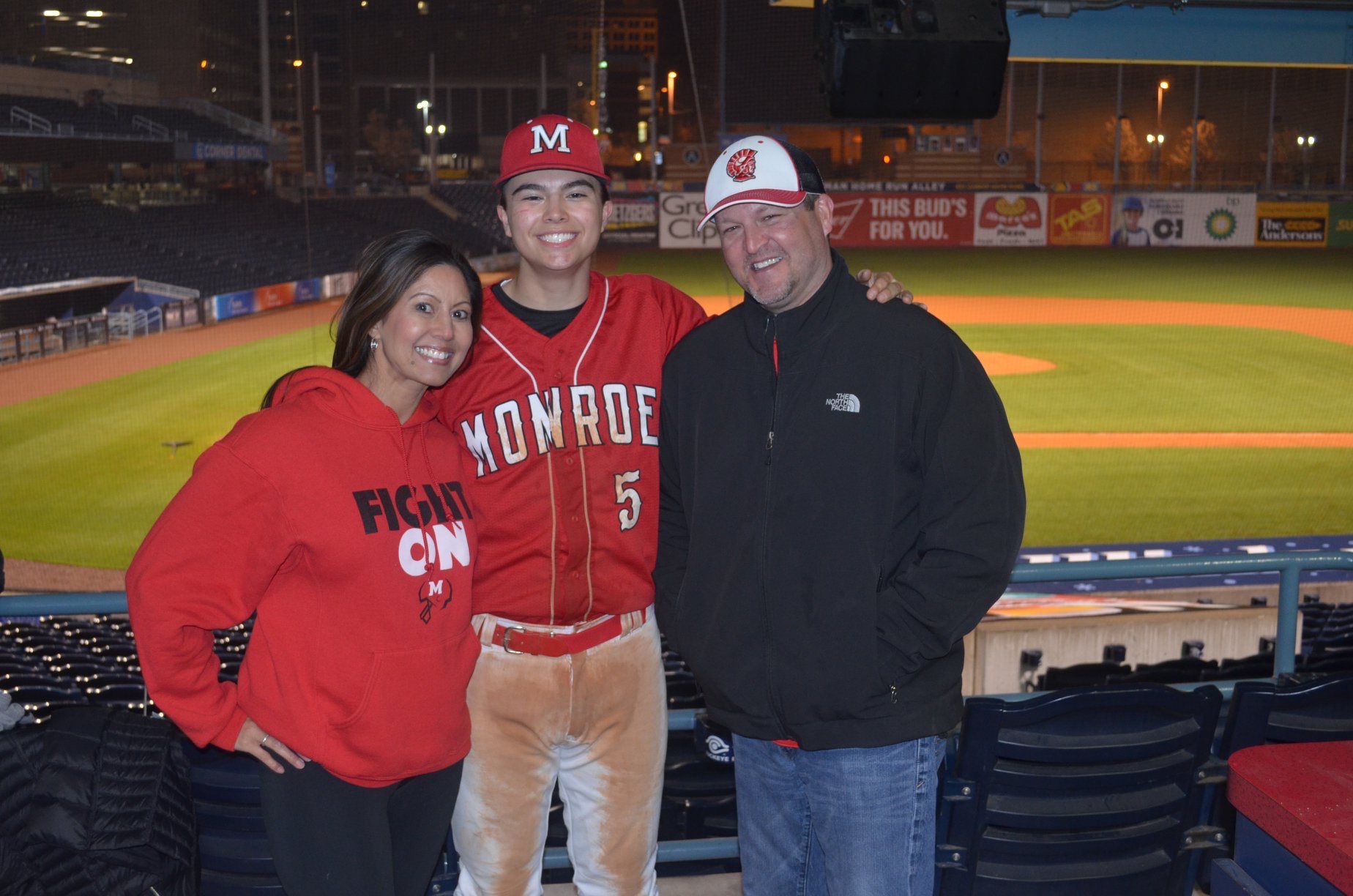 Hall family smiling, son in baseball uniform