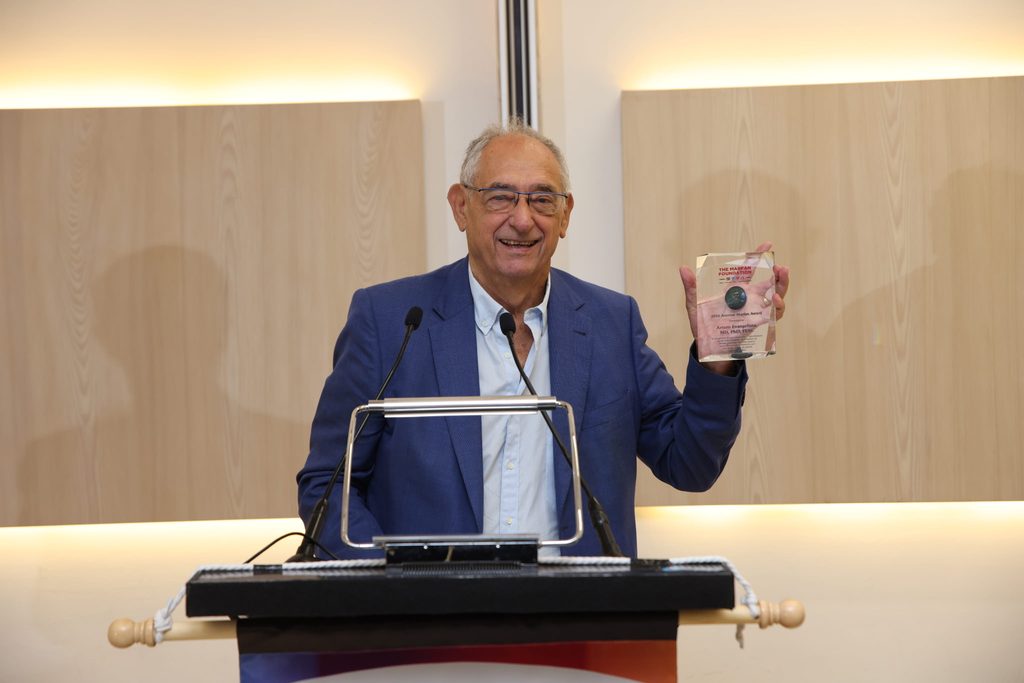 El Dr. Arturo Evangelista sonríe en el podio mientras sostiene el Premio Antoine Marfan 2026.