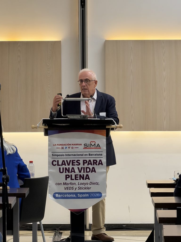 El Dr. Juan Bowen, de Mayo Clinic, habla en un podio con el cartel del simposio "Claves para una vida plena" en Barcelona, España, 2026.